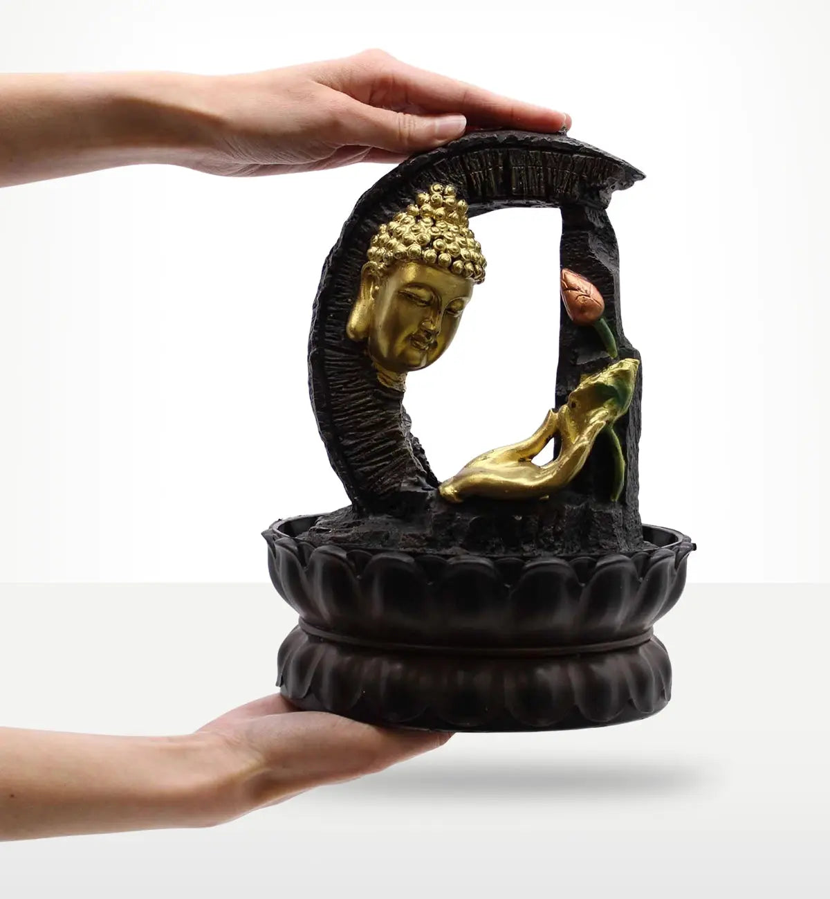 Hands holding a Tabletop Water Feature - 30cm - Golden Buddha & Lotus with a black base, golden Buddha head, and lotus flower detail in a serene design.