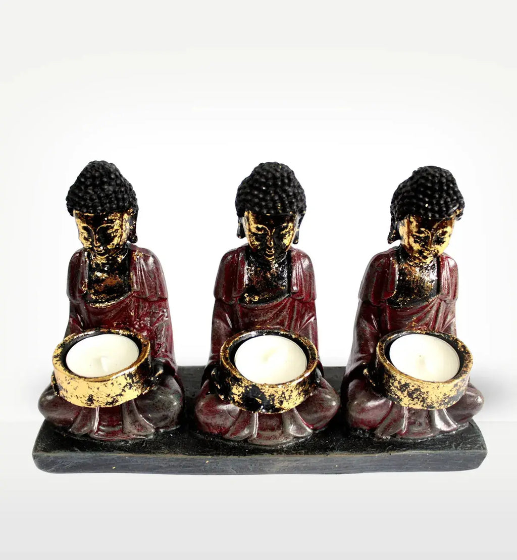 Antique Buddha - Three Devotees Candle Holder featuring three hand-painted Buddha figures in meditative poses holding round candle holders, with a distressed antique finish.