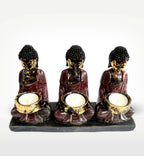 Antique Buddha - Three Devotees Candle Holder featuring three hand-carved Buddha figures in dark red and gold tones, each holding a candle cup on a black base, perfect for serene decor.