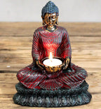 Antique Buddha - Devotee Candle Holder featuring a hand-painted resin Buddha statue in meditative pose, holding a lit candle with intricate detailing and vibrant red and gold tones.