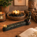 A serene Antique Buddha - Incense Burner & Box featuring a hand-painted Buddha figure seated on a detailed carved base holding a small candle, set on a wooden surface with warm ambient lighting.
