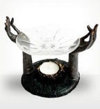 Antique Buddha - Om Hands Oil Burner featuring two sculpted hands in a meditative gesture supporting a glass dish above a tealight candle holder in a rustic dark finish.