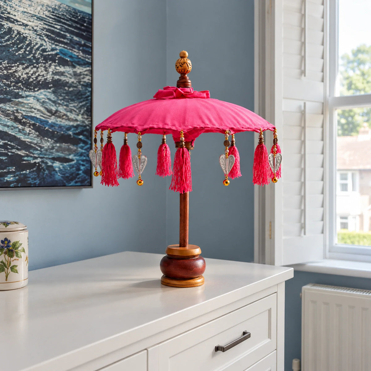 Bali Indoor Umbrella Home Decor Parasol, Cotton, Pink- 40cm on a chest of drawers in a British bedroom.