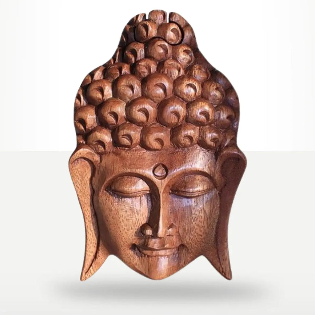 A carved wooden Buddha head wall sculpture with detailed curls in the hair, closed eyes, and a serene expression, shown against a light gray background.