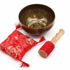 Brass Golden Tara - Special S'Bowl Set featuring a hand-etched brass singing bowl with intricate designs, a red cushion with gold embroidery, and a wooden striker with a red suede tip.