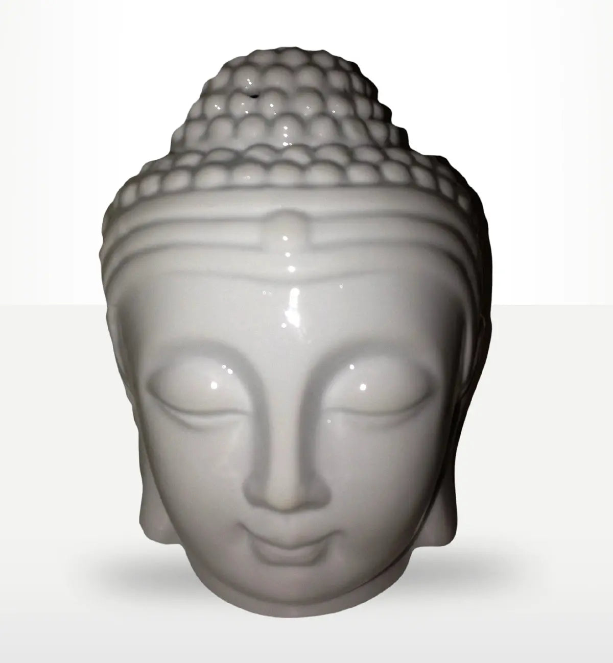 White ceramic Buddah Head Oil Burner - White with smooth, serene facial features and detailed textured hair, ideal for peaceful home decor and Buddha-themed oil burning.