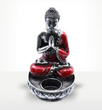 Buddha Candle Holder - Red - Medium featuring a serene Buddha figure in red and silver tones seated in meditation pose with hands in prayer, designed to hold a candle.