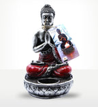 Buddha Candle Holder - Red - Medium featuring a meditating Buddha statue in a prayer pose with a red robe and a decorative base designed to hold a candle.