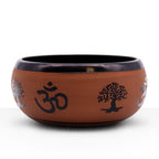 Earth Powder Singing Bowl - Clay Om Buddha - 16cm featuring a clay finish with black Om symbols and tree motifs around its exterior for meditation and sound therapy.