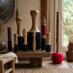 A collection of handcrafted wooden and felt decorative objects displayed on a rustic wooden bench in a warm, styled interior setting.