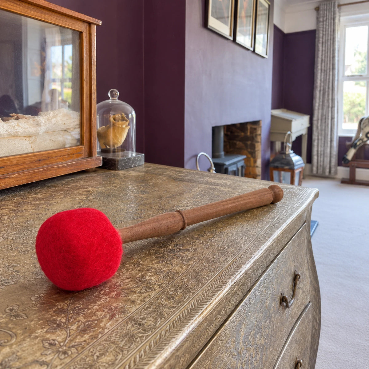 Extra Large Felted Gong Mallet, 30cm lying on a chest in a British sitting room.