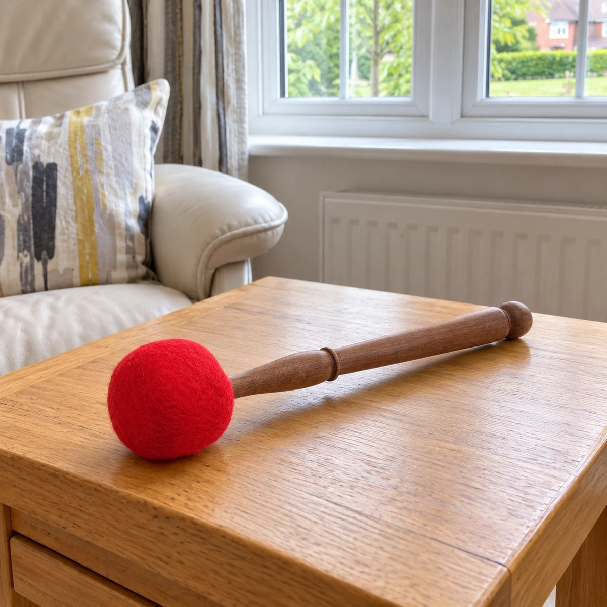 Large Felted Gong Mallet, 23cm lying on an oak side table in a British sitting room.