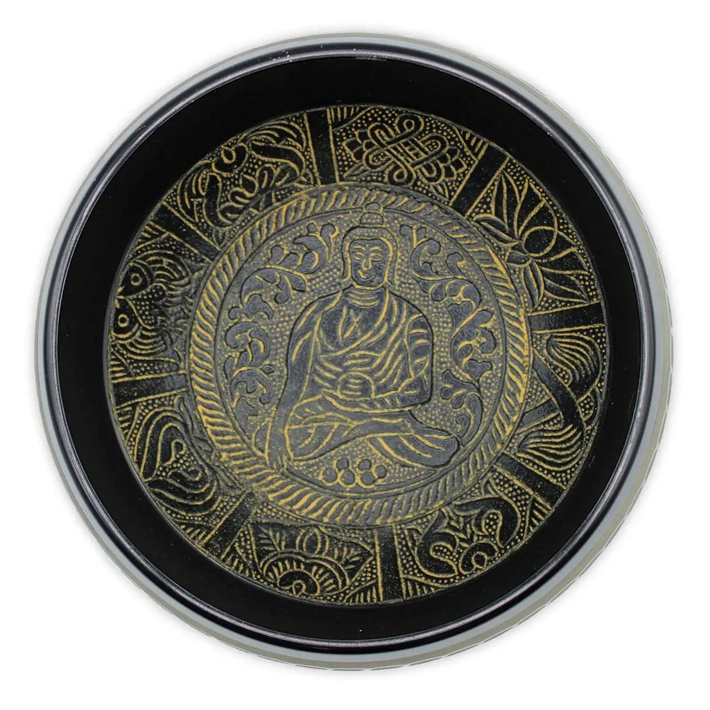 Top-down view of a black and gold singing bowl featuring a detailed brass Buddha figure surrounded by intricate traditional patterns, named Extra Loud - Singing Bowl - One Buddha.