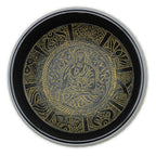 Top-down view of a black and gold singing bowl featuring a detailed brass Buddha figure surrounded by intricate traditional patterns, named Extra Loud - Singing Bowl - One Buddha.