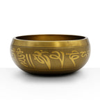 Ganesh Singing Bowl made of brass with intricate golden script engraving around its rounded exterior, designed for meditation and spiritual practices.