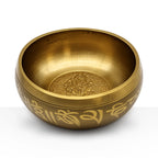 Ganesh Singing Bowl made of brass with intricate engraved design of Ganesh inside and decorative script around the outer edge, used for meditation and sound therapy.