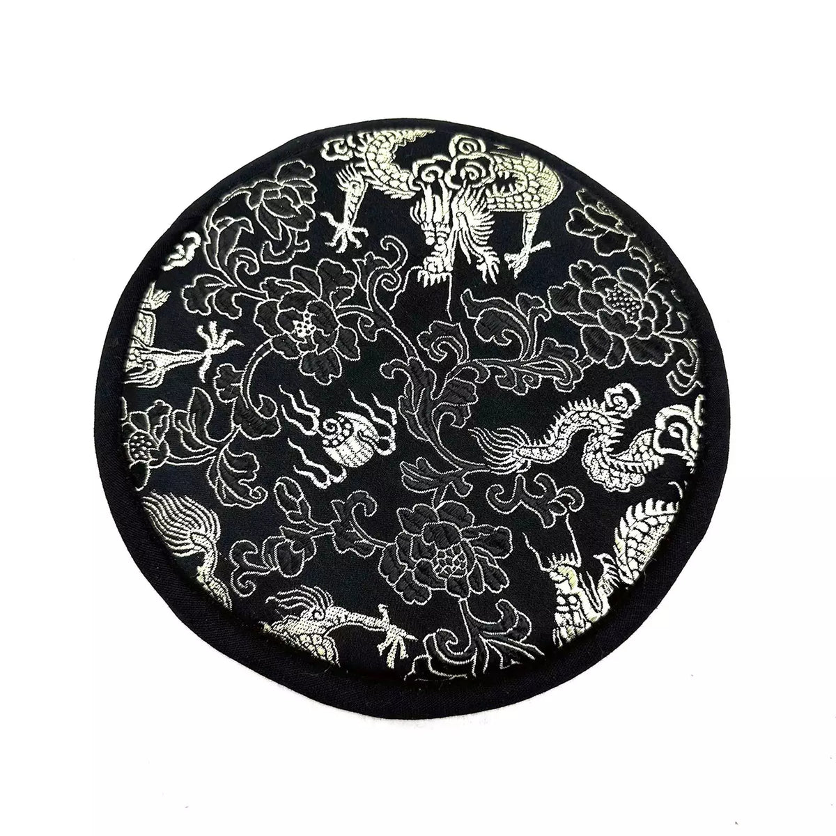 Black circular mat with white floral and dragon designs on a white background