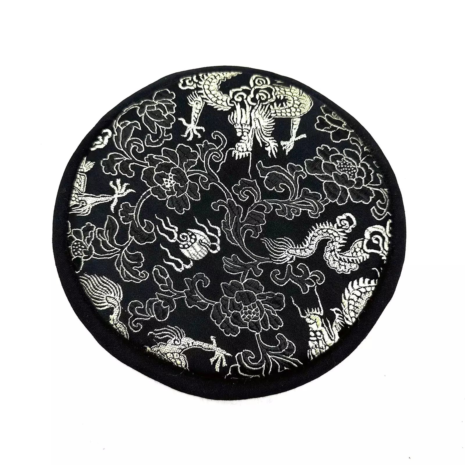 Black circular mat with white floral and dragon designs on a white background