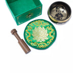 Decorative green and gold items including a bowl, coaster, and wooden tool on a white background.