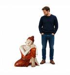Man standing next to a large Hand Carved Wooden Buddha Statue - 25cm Thinking, featuring a serene seated Buddha with detailed carving and reddish-brown robes.