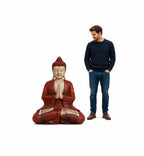 Man standing next to a Hand Carved Wooden Buddha Statue - 40cm Welcome, featuring intricate details and a serene meditative pose in red and natural wood tones.