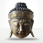 A bronze-finished Buddha head sculpture with closed eyes, ornate hair detail, and a decorative headband, shown against a light gray background.