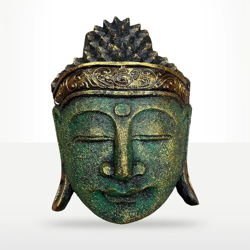 A decorative Buddha head sculpture with a textured green patina finish and gold accents on the crown and forehead, shown against a light gray gradient background.