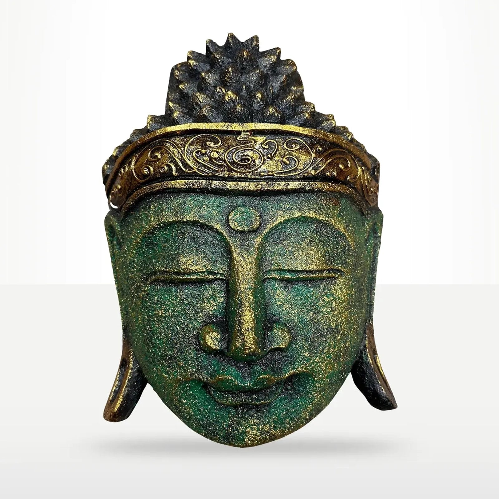 A decorative Buddha head sculpture with a textured green patina finish and gold accents on the crown and forehead, shown against a light gray gradient background.
