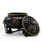 Large Brass Tibetan Burner - Four Symbol Hanging Pot with ornate design, dark brass finish, intricate patterns on lid, and decorative side accents, standing on three detailed legs.
