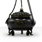 Large Brass Tibetan Burner - Four Symbol Hanging Pot with intricate brass detailing, perforated lid, and ornate tripod legs suspended by twisted chains.
