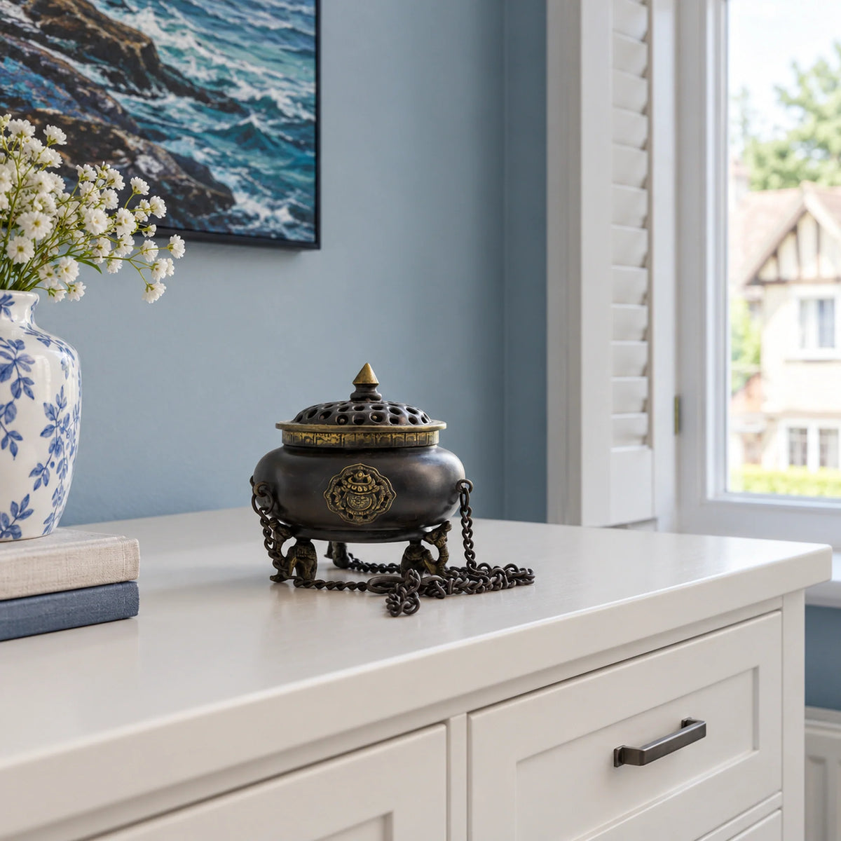 Large Brass Tibetan Incense Burner, Four Symbol Hanging Pot on a chest of drawers in a British bedroom.