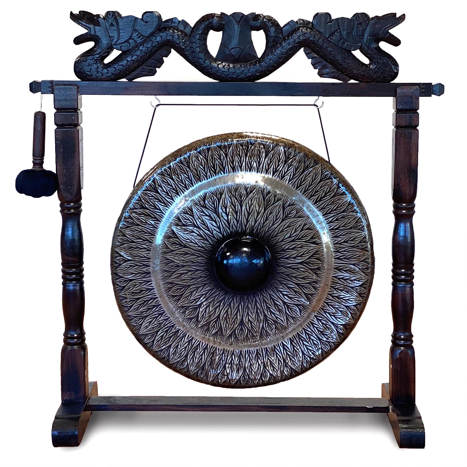 A large decorative gong with an engraved floral or leaf-like pattern, mounted on a dark wooden stand with carved dragon-like details at the top and a hanging mallet on the left, shown against a plain white background.