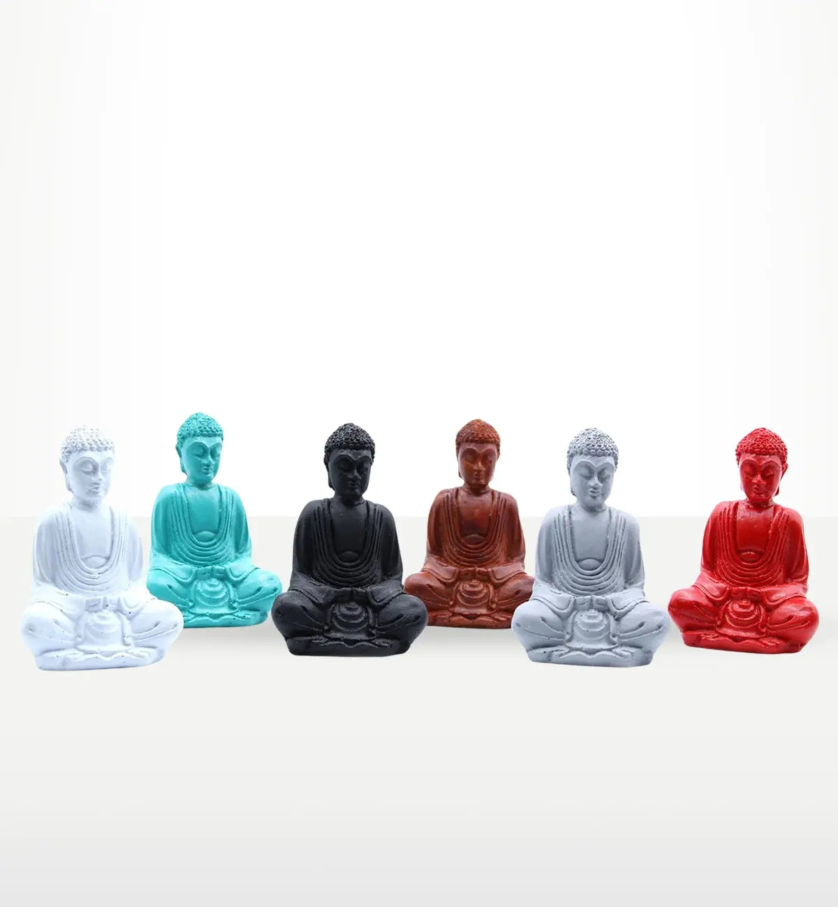 A collection of six Matt Mini Buddha (Assorted Colours) statues in white, teal, black, brown, light grey, and red, displayed in a serene seated meditation pose.
