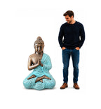 Man standing next to a Med Large Turquoise & Gold Praying Buddha Statue - 1.2m Tall, showcasing a hand-carved Buddha statue with intricate turquoise and gold detailing.
