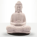 A seated Buddha statue in a light stone-like beige color with a textured, crackled finish, resting on a round black base against a white studio background.