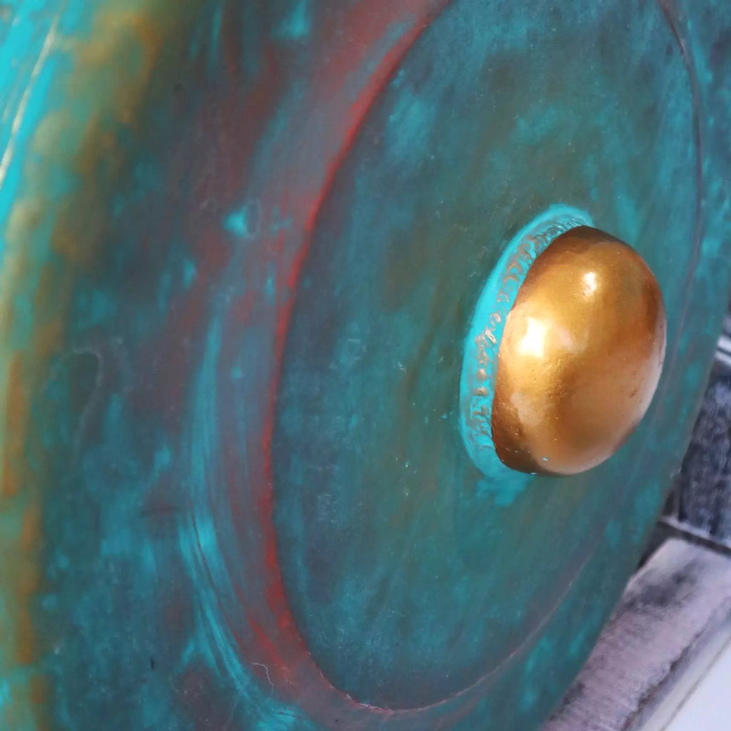 Close-up of a large gong with a gold center on a textured surface