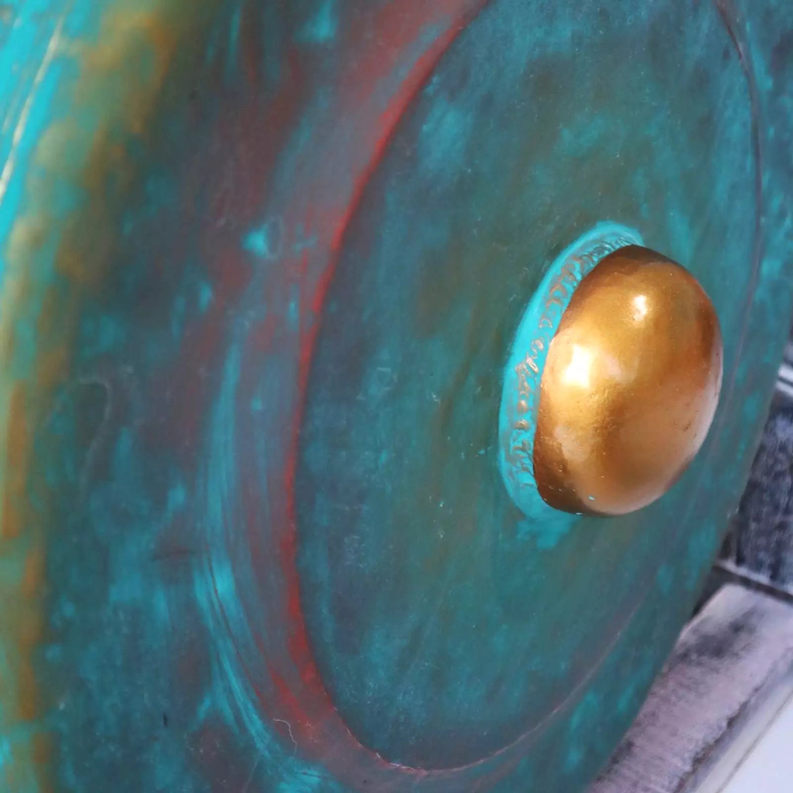 Close-up of a large gong with a gold center on a textured surface