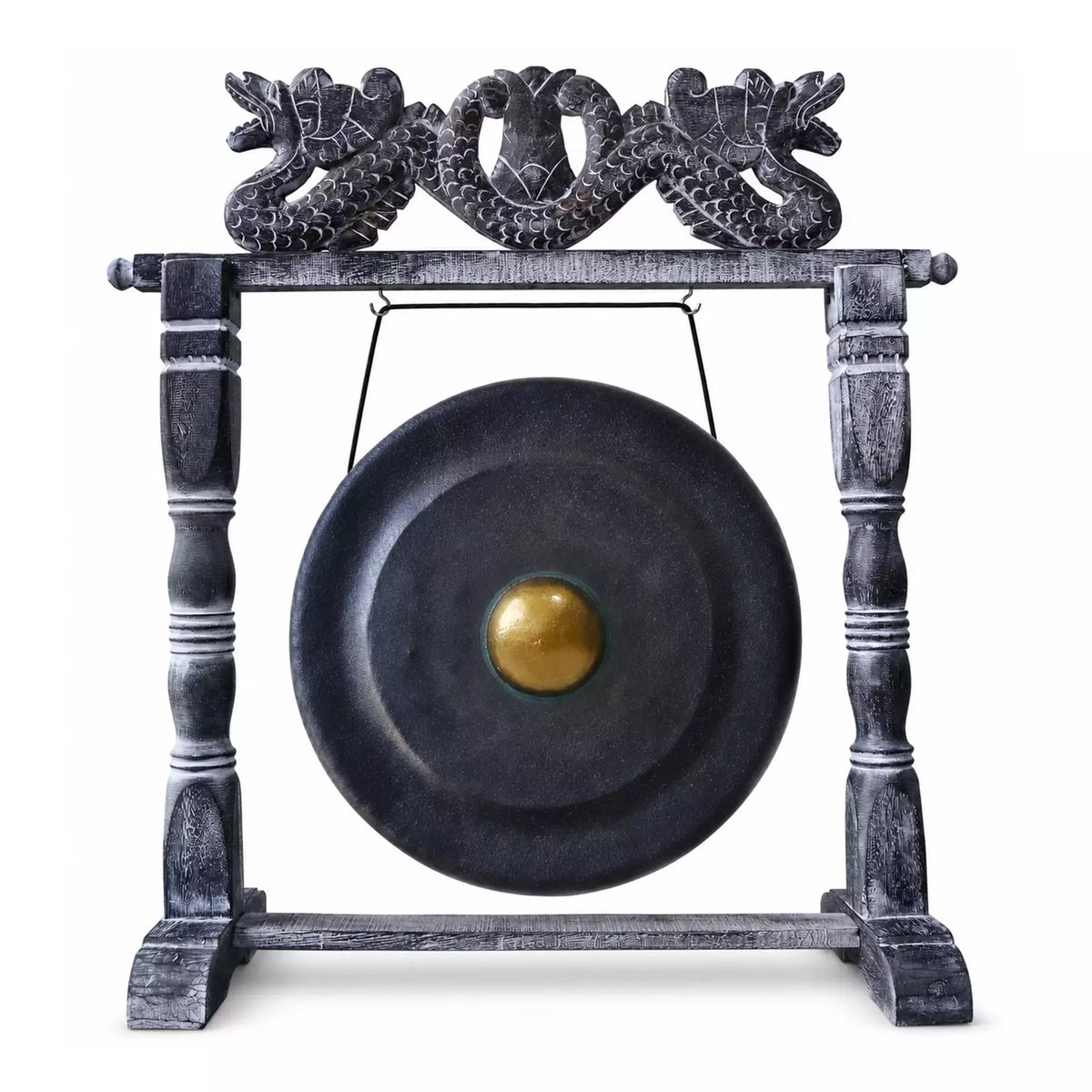 A large round black gong with a gold-colored central boss, suspended from a dark wooden stand featuring ornate dragon carvings at the top, isolated on a white background.