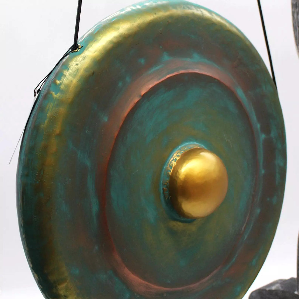 Decorative gong with gold center and greenish-blue finish on a white background
