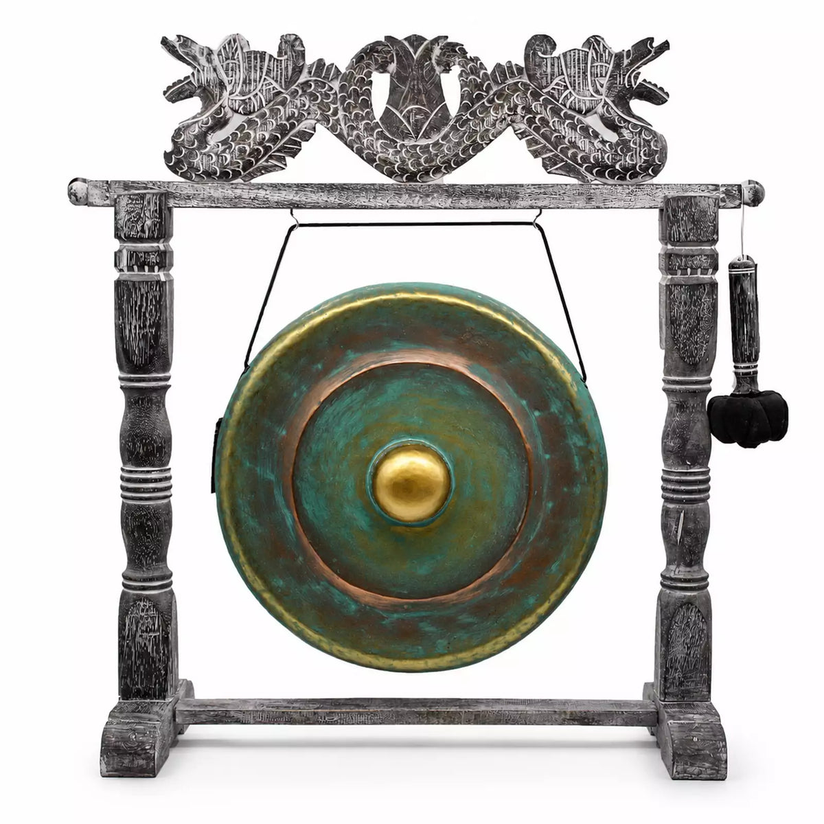 A decorative gong set on a carved stand, featuring a round green and bronze gong with a gold center, suspended by a wire from a weathered gray wooden frame topped with a dragon motif, and a hanging mallet on the right.