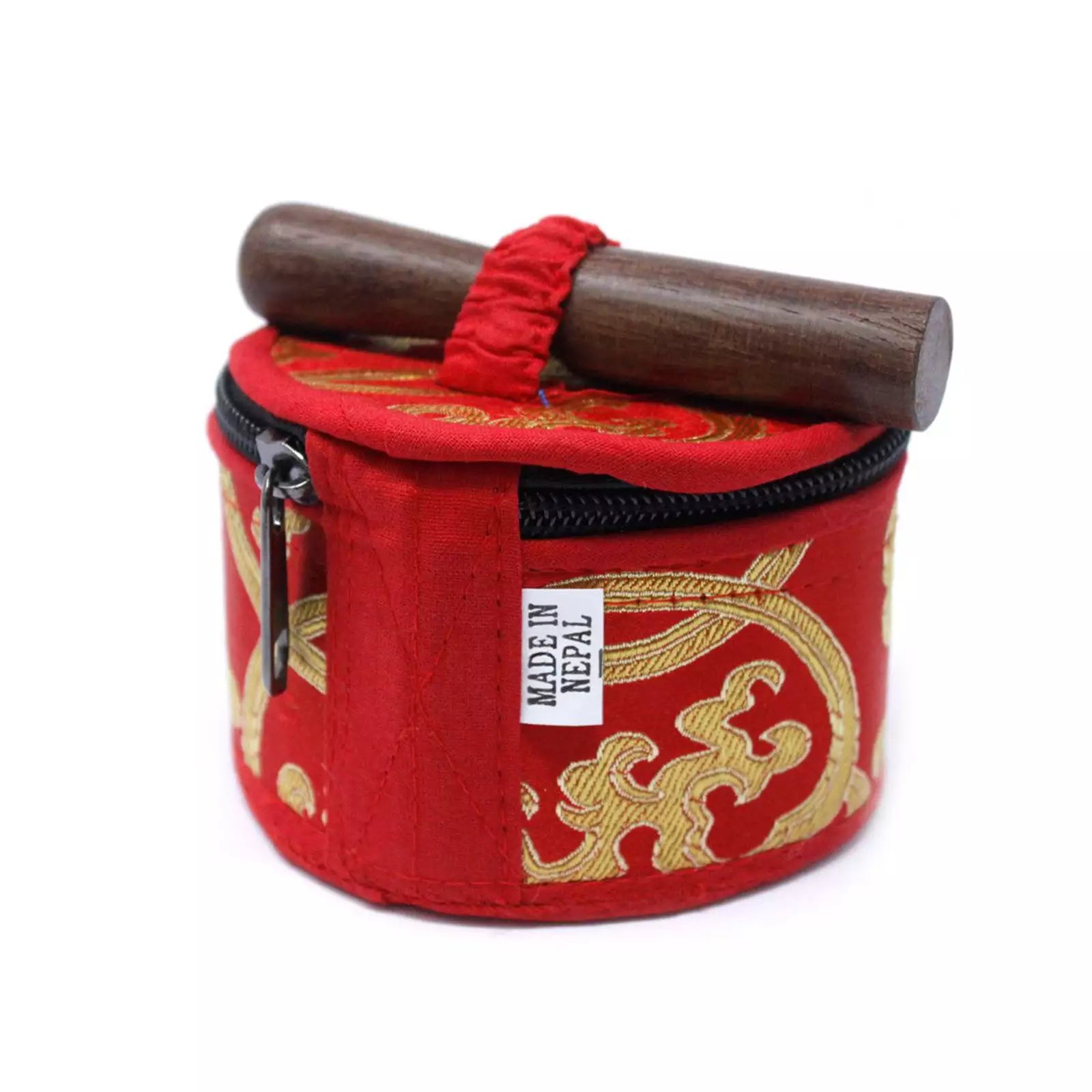 A red cylindrical fabric pouch with gold embroidered patterns, a black zipper, a red elastic loop, and a wooden mallet resting across the top. A small white tag reads 'MADE IN NEPAL'.