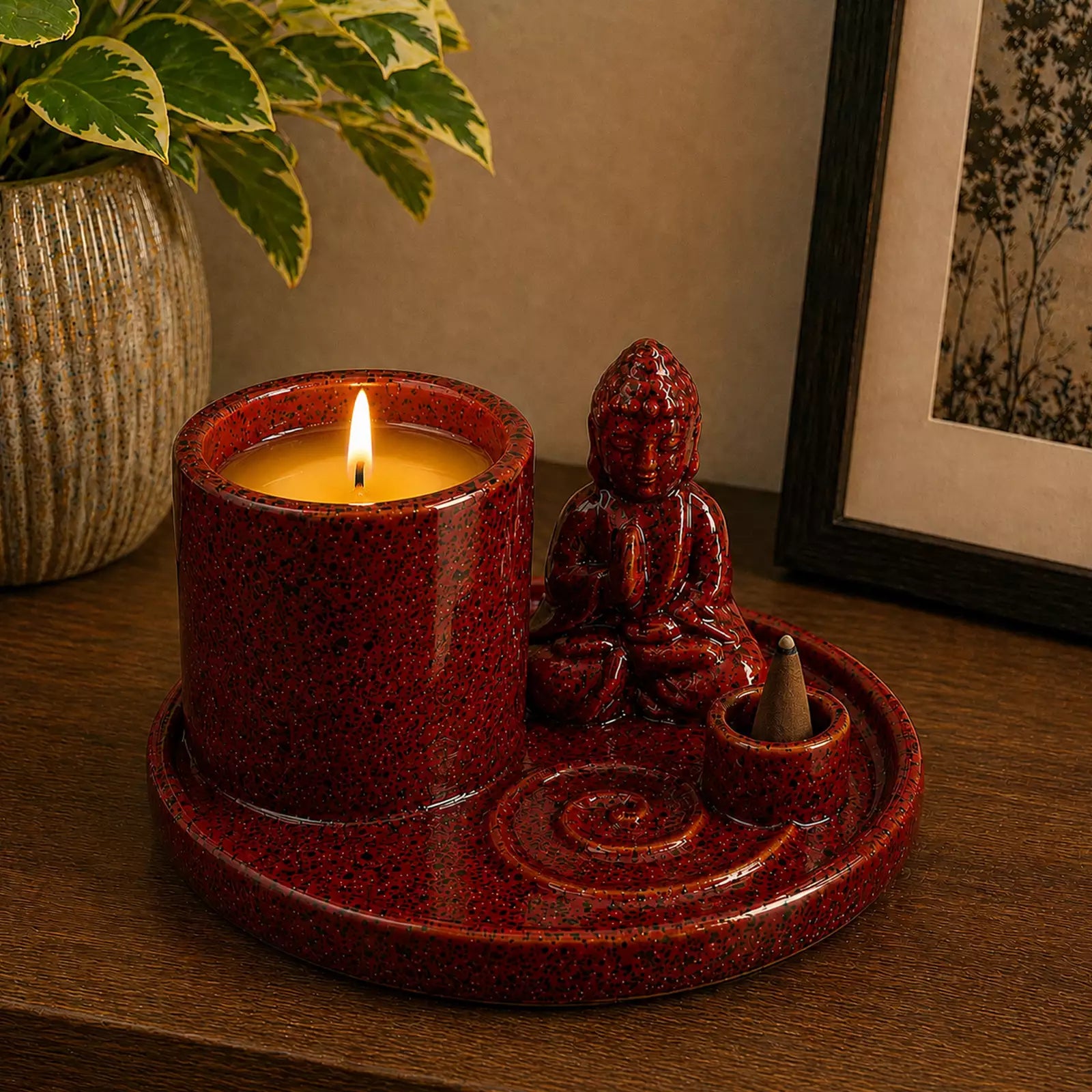 Multi Purpose Buddha Incense Plate - Ceramic Soft Red featuring a seated Buddha figure, holder for two burning incense sticks with smoke, and a double wick candle on a wooden surface.