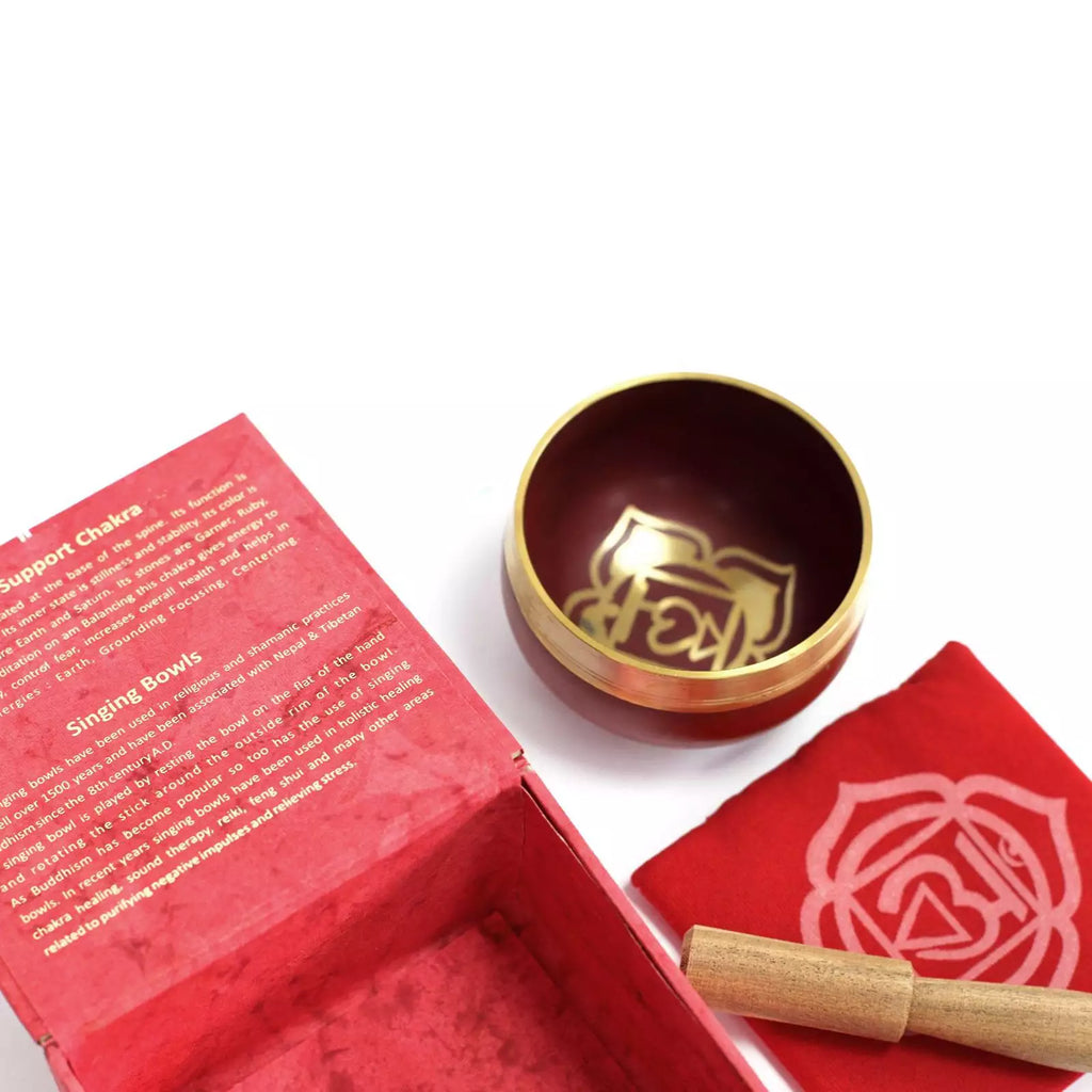 Red singing bowl set with a gold bowl and wooden stick on a white background