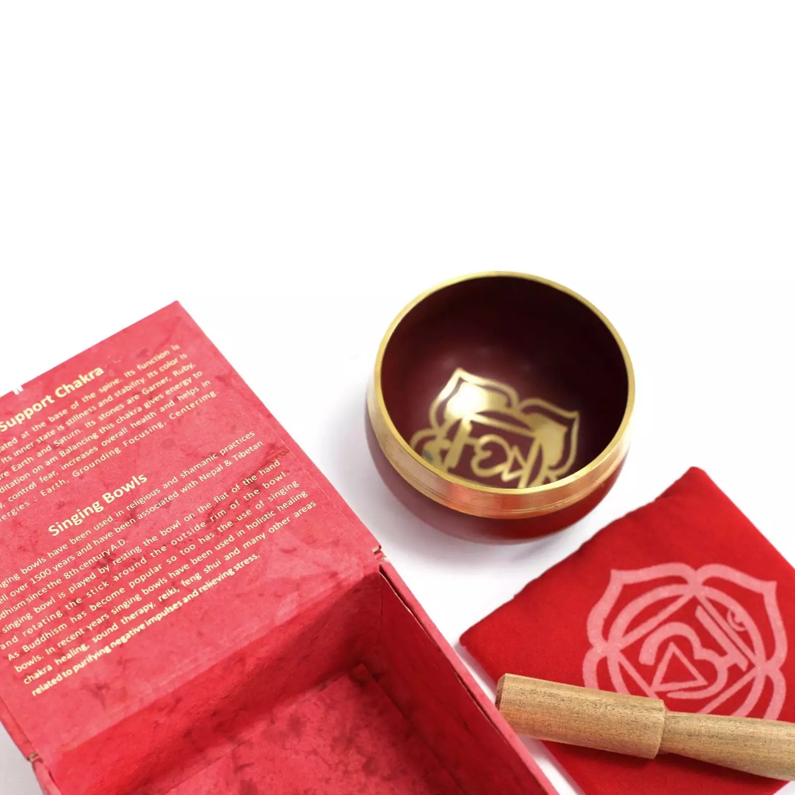 Red singing bowl set with a gold bowl and wooden stick on a white background