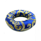 A blue satin ring-shaped cushion with an ornate gold damask pattern, photographed on a plain white background.