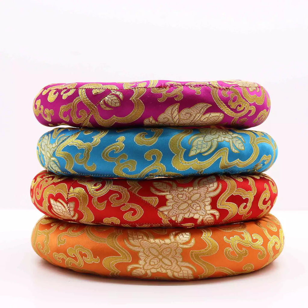 Four round woven cushion pads stacked vertically, featuring traditional Chinese brocade patterns in magenta, blue, red, and orange with gold detailing, on a white background.