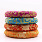 Four round woven cushion pads stacked vertically, featuring traditional Chinese brocade patterns in magenta, blue, red, and orange with gold detailing, on a white background.