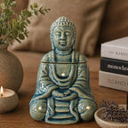 Sitting Buddha Oil Burner - Blue, a serene ceramic Buddha figure with smooth blue glaze, designed as an oil burner emitting gentle smoke, ideal for calming home décor.