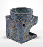 Square Buddha Burner - Dusty Blue made of ceramic with textured glazed finish, featuring Buddha motifs on each side and a hollow section for incense or oils.