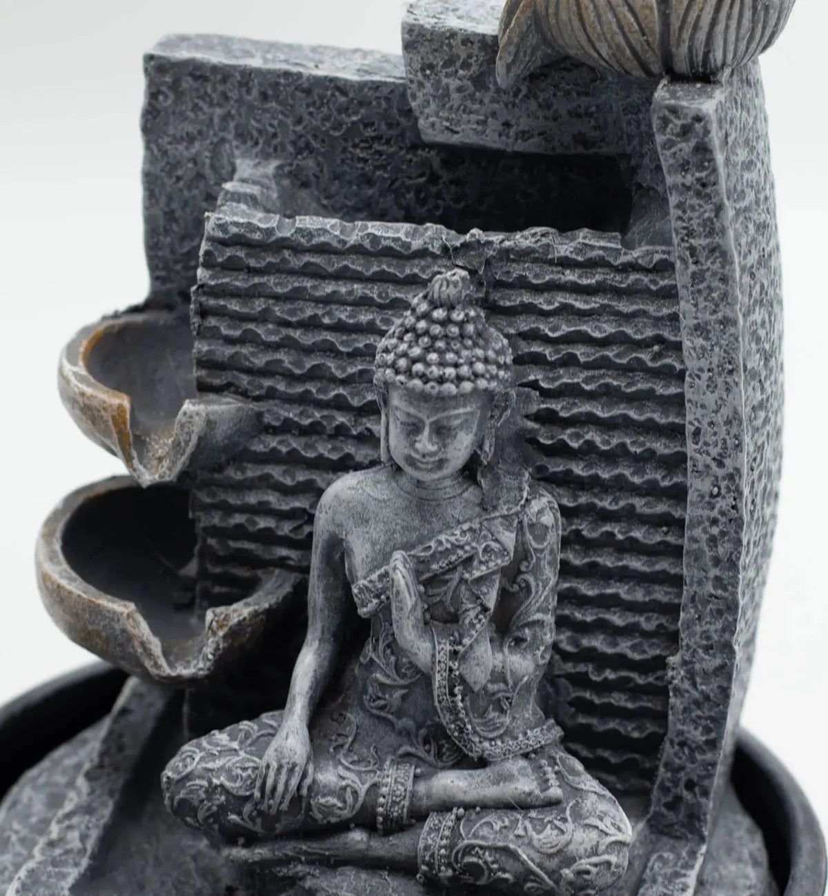 Close-up of a serene Buddha seated in meditation on the Tabletop Water Feature - 19x19x28cm - Buddha, Lotus Flower Cascading Potsx with textured cascading lotus flower pots in calming gray tones.